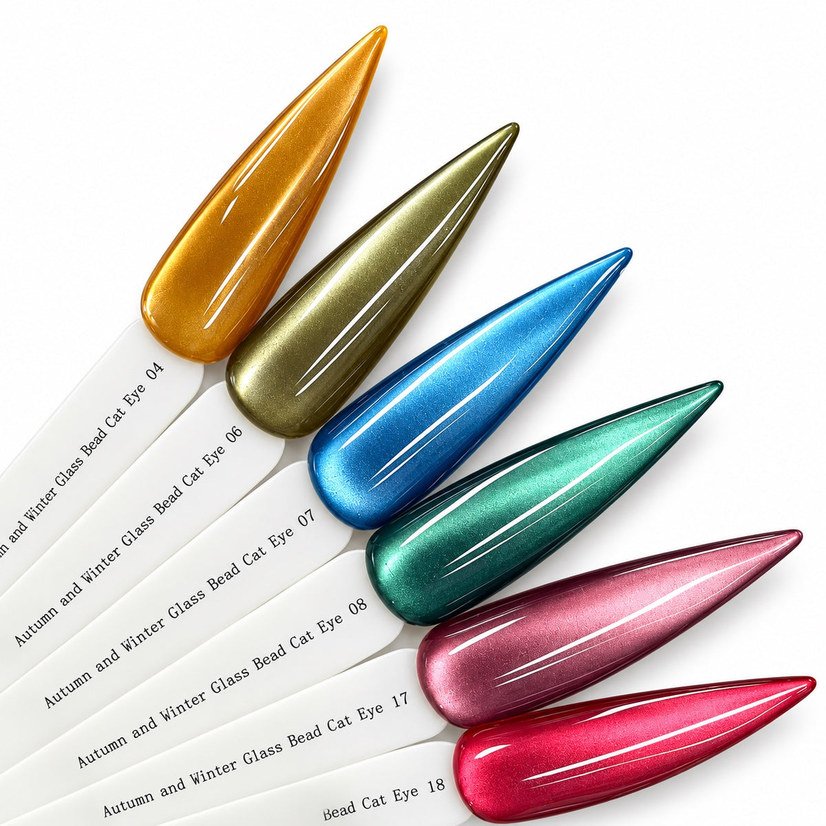 Six glass bead cat eye gel polish swatches: amber gold, olive khaki, steel blue, emerald teal, dusty mauve and raspberry red