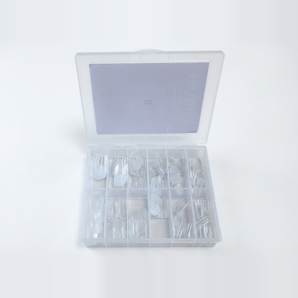 Clear soft gel nail tips sorted by size in the open storage box